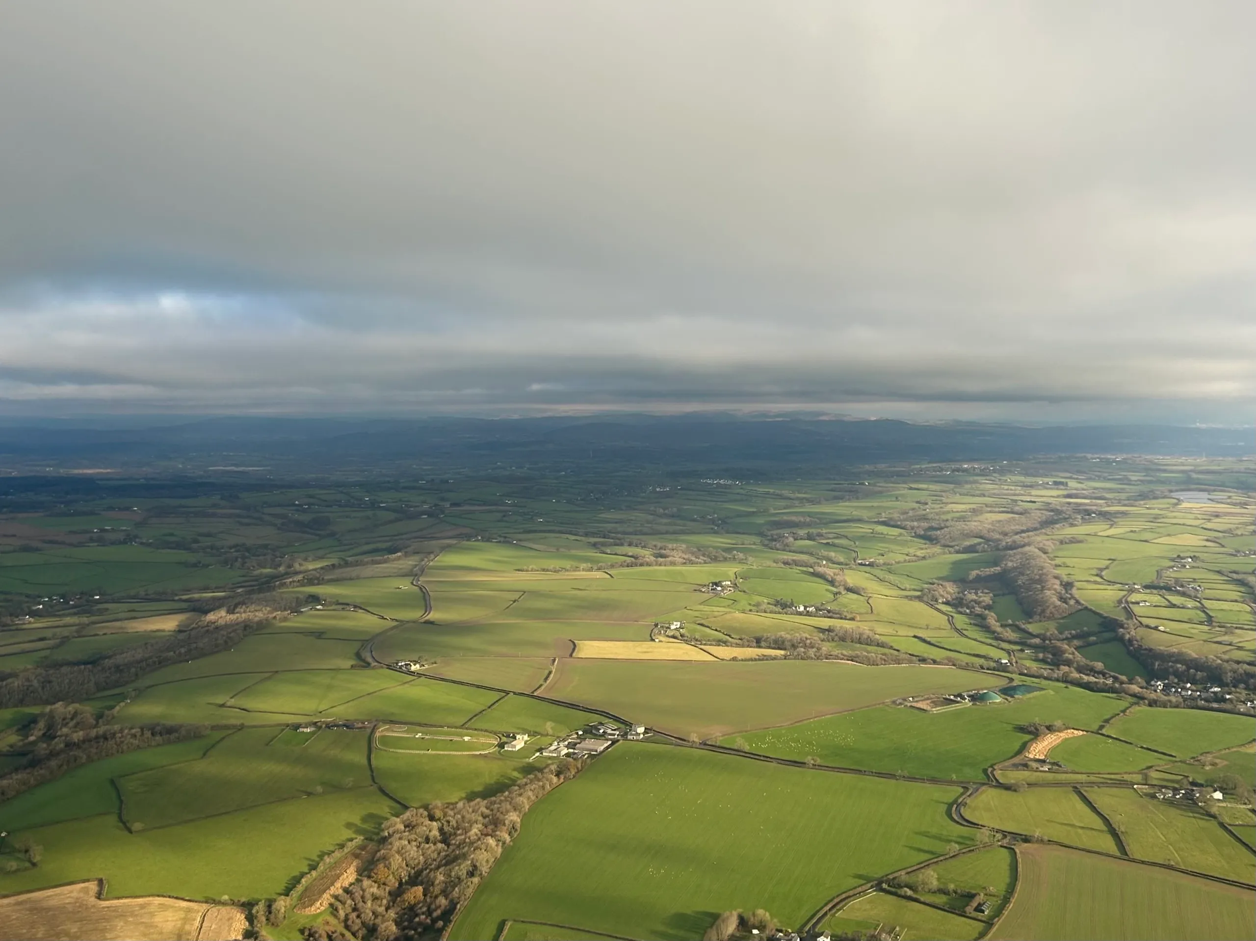 Aerial view of a patchwork of cultivated farmland stretching to the horizon
